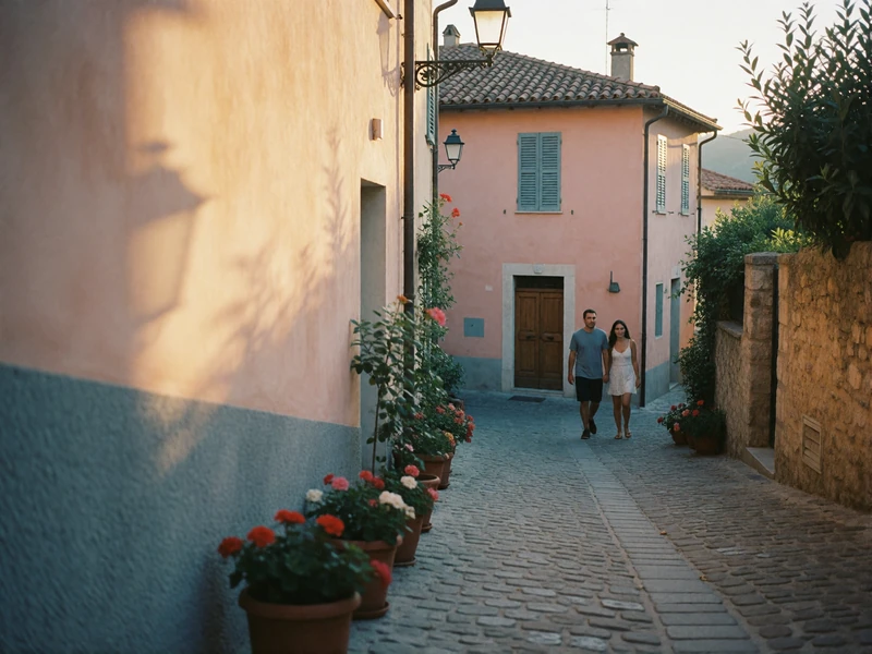 Couple walking through a quiet cobbled lane in a pastel European hilltown